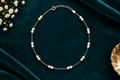 925 silver pearl anklet flat lay on teal velvet