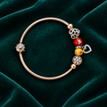 925 silver rose gold charm bangle flat lay on teal velvet