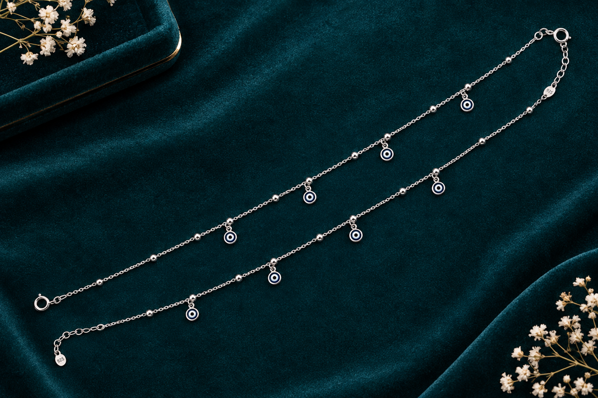 925 silver evil eye anklet flat lay on teal velvet